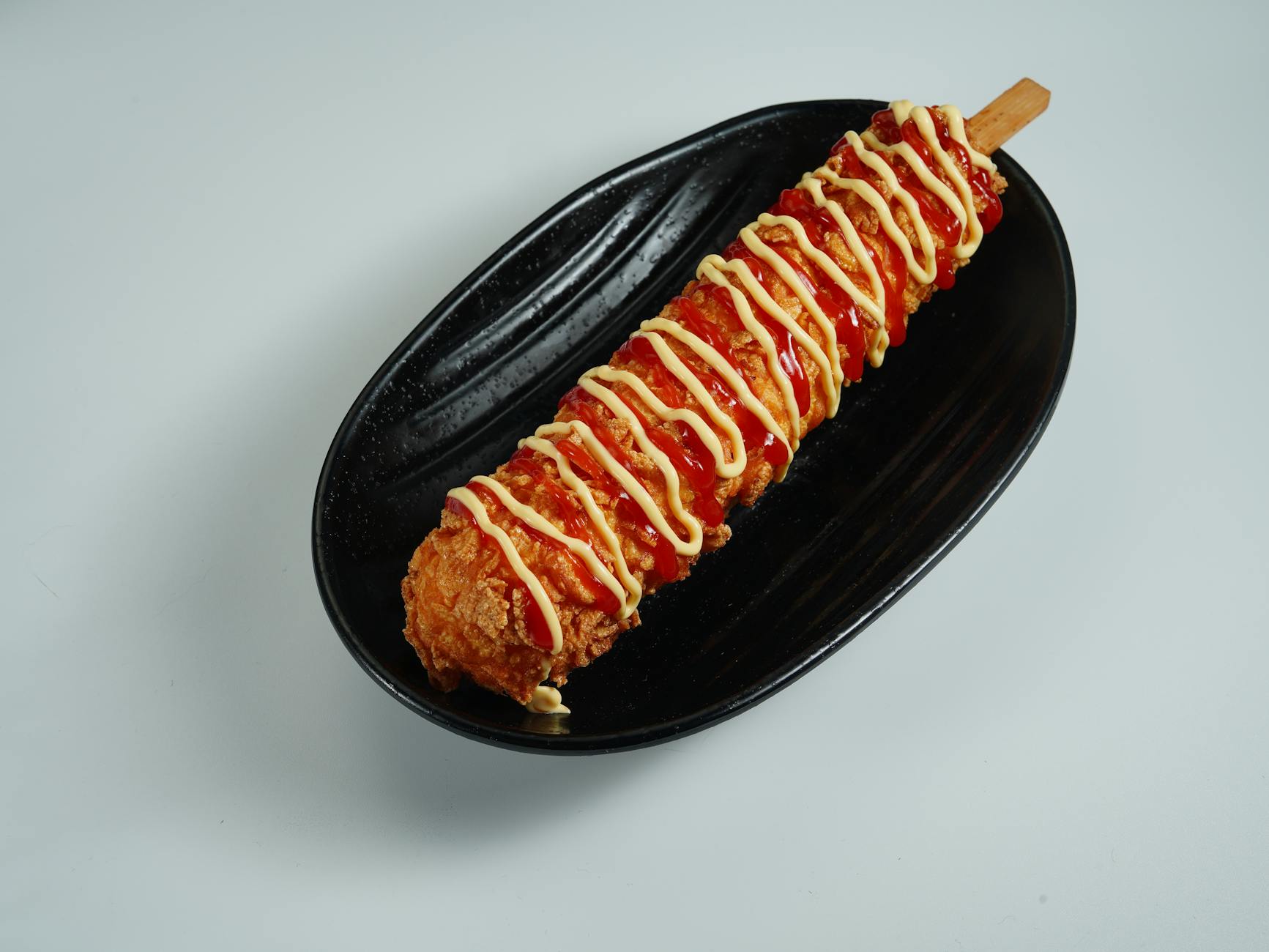 korean corn dog topped with ketchup and mustard