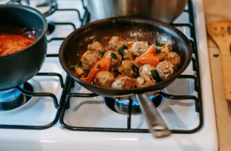 pan with saucy meatballs frying on gas stove in kitchen Fogão a Gás o guia definitivo