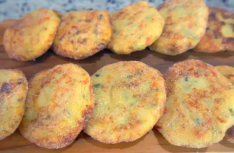 Croquetes de batata com queijo dourados e crocantes, cortados ao meio para mostrar o recheio de muçarela derretida, servidos em prato com molhos.